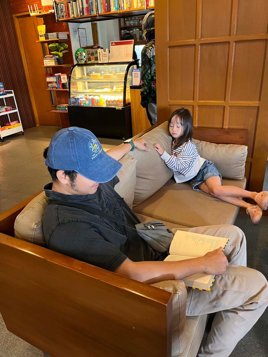 A father and daughter relaxing on the lounge couches